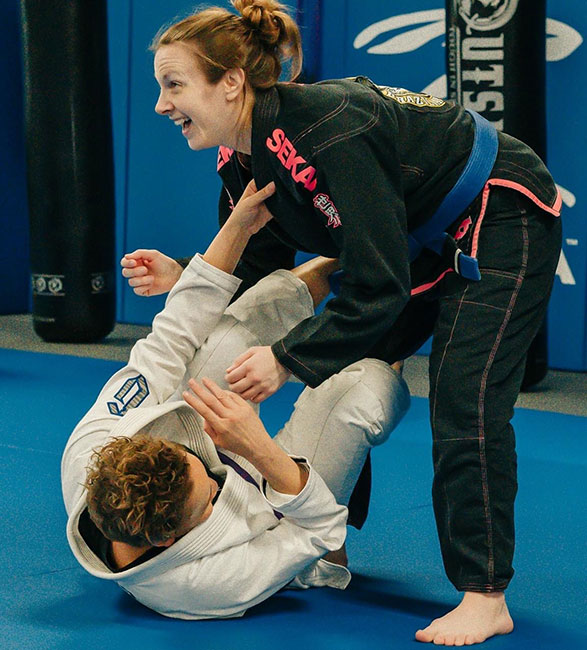 two females training jiu jitsu